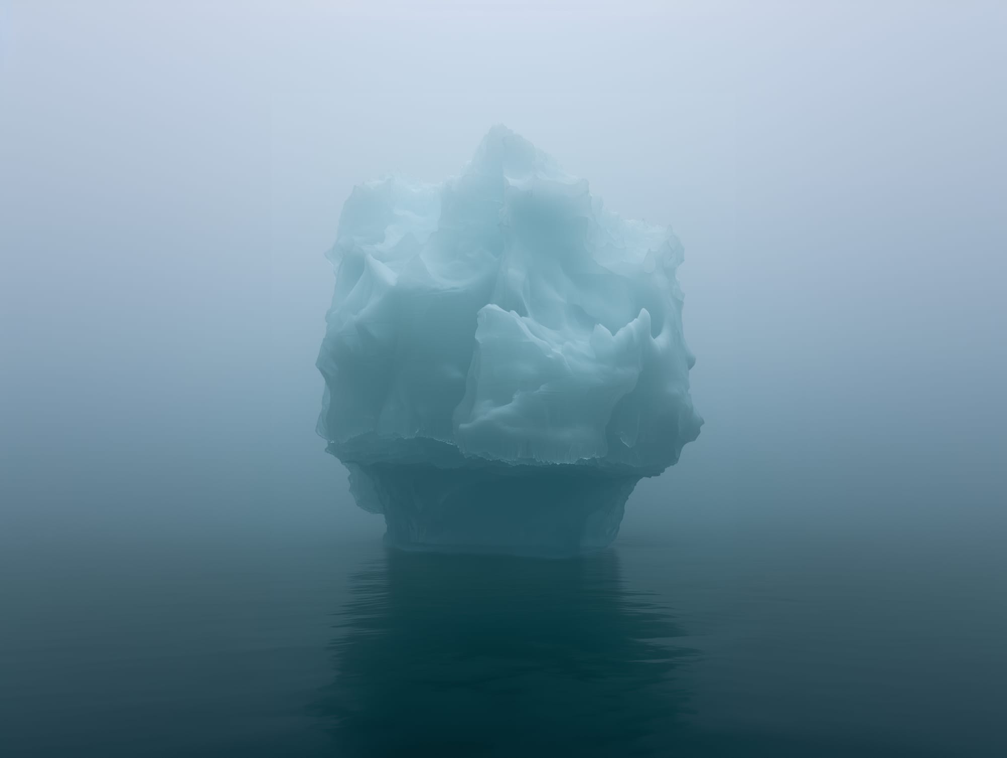 Large iceberg floating in calm, foggy ocean water.