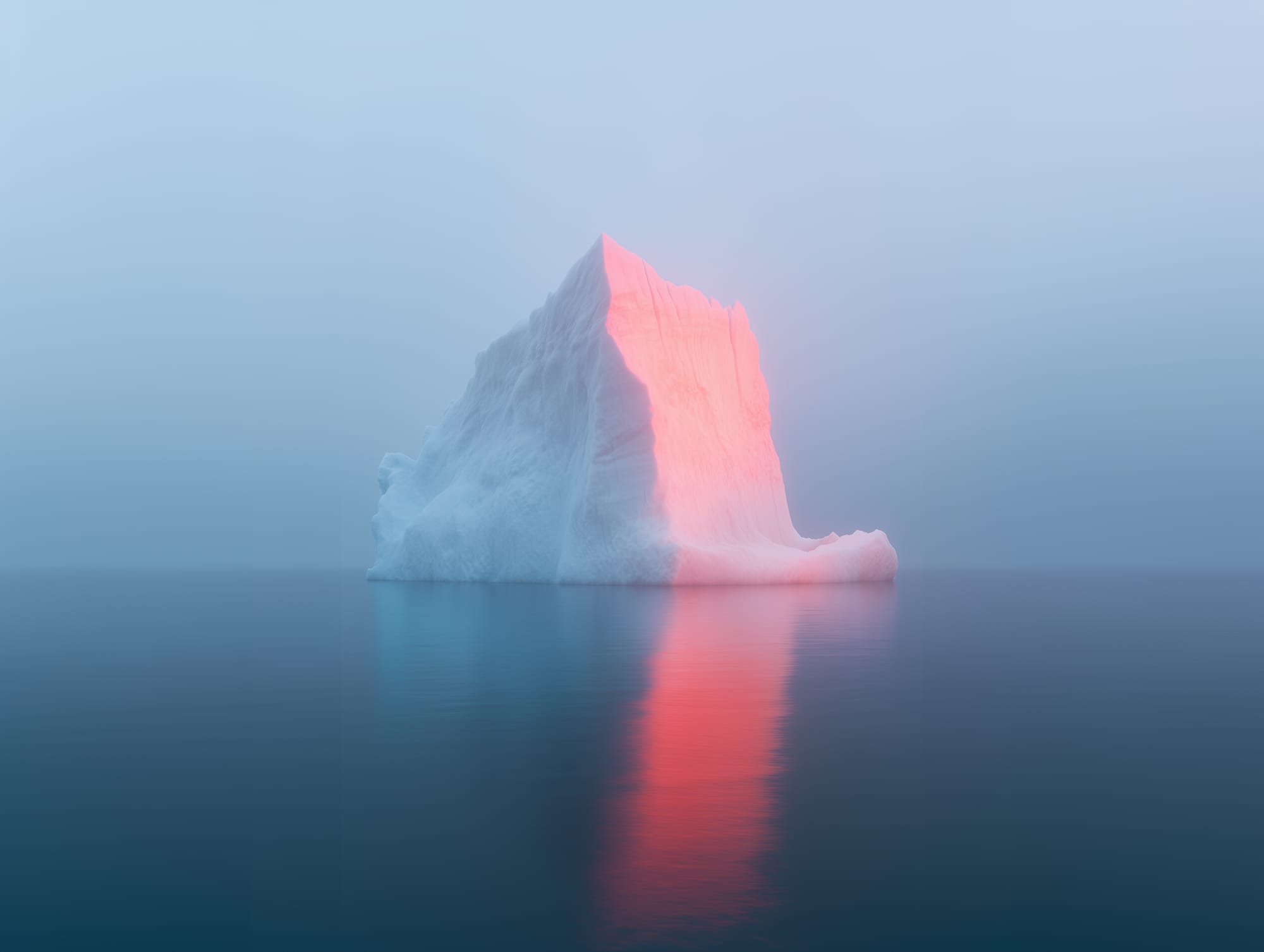 A large iceberg floating in calm ocean water, with soft pink and blue hues reflecting on its surface, under a clear sky.