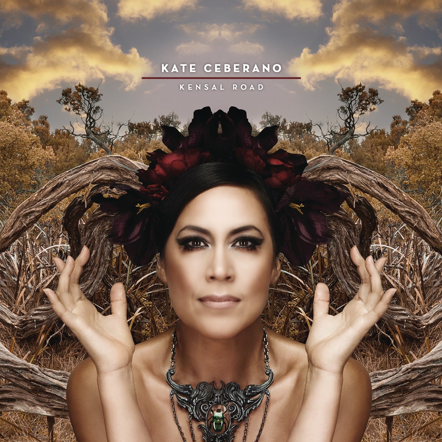 The Kensal Road album cover: Kate Ceberano in a crown of dark red flowers, hands raised, framed by mirrored driftwood and gold-lit clouds.