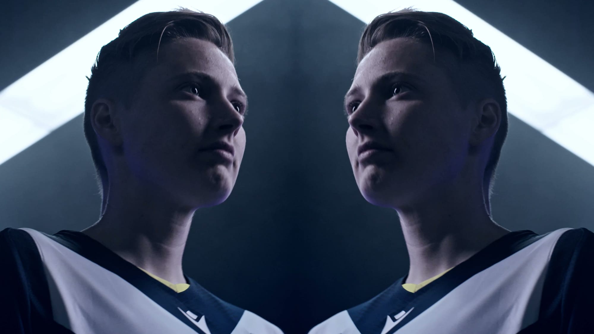 Two players from the women's squad mirrored nose to nose, both looking up into the light